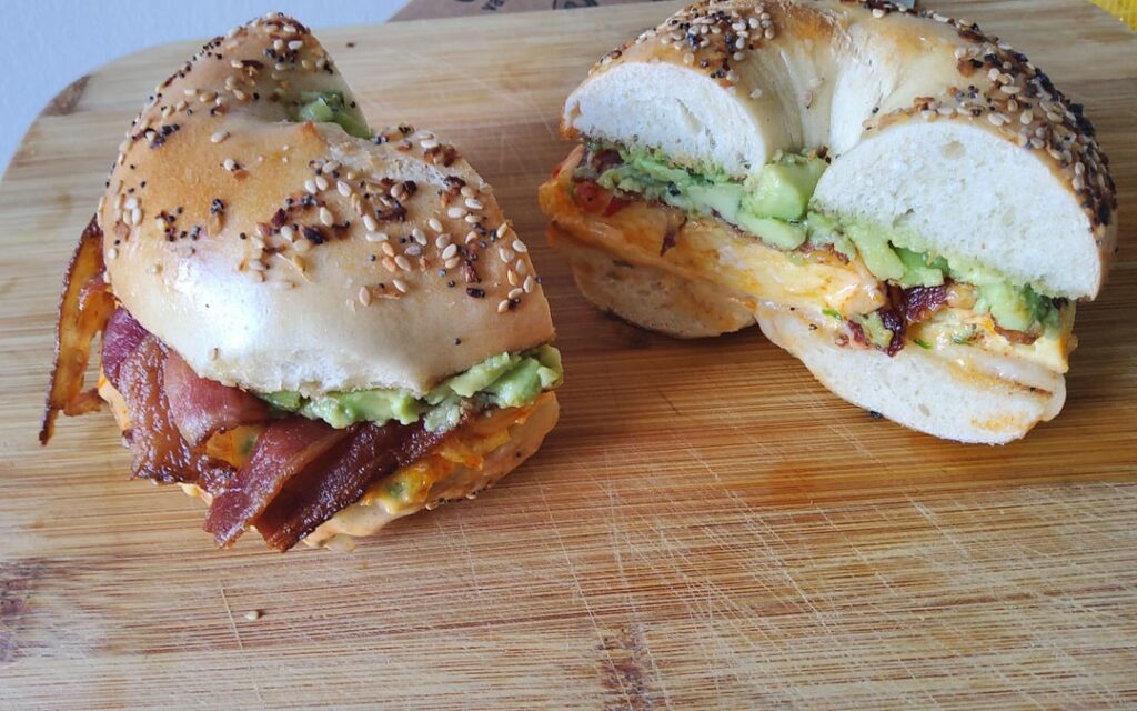 Bacon egg cheese avocado breakfast sandwich on everything bagel.