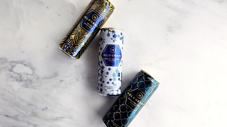 Cans of Melograno on marble surface