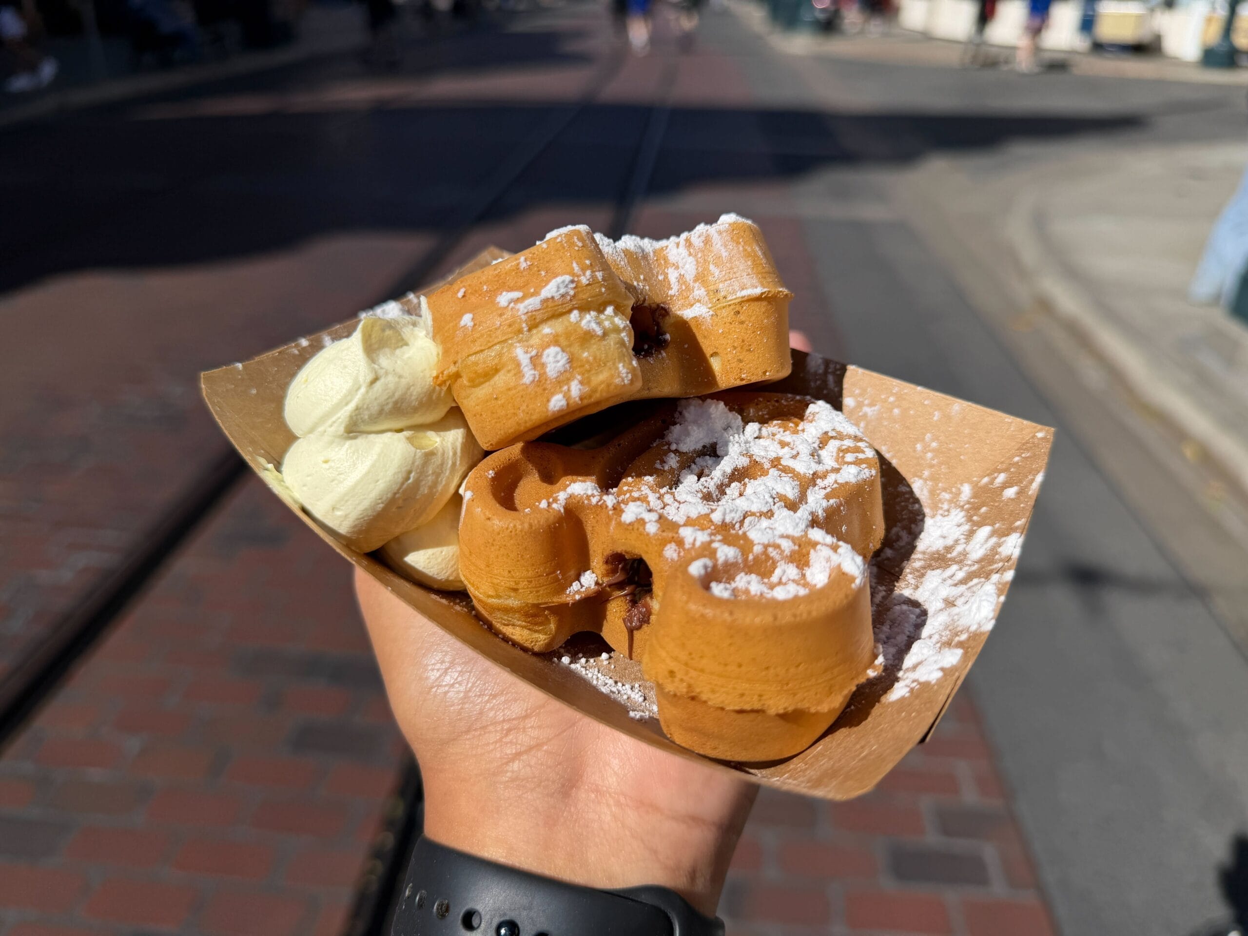 Fake banana, there is no way around that, but probably one of the best fake bananas we’ve had. The Hazelnut Mickey Waffles are exactly what you would expect, nothing fancy or spectacular, but solid and yummy. The banana cream is typical Disney fresh-made thick whipped cream, and the flavor is subtler by itself but amplified by the hazelnut when eaten together. Not for everyone, and not a must-get, better than average, but neither of our favorites. If you’re a Banana lover, give it a try!
