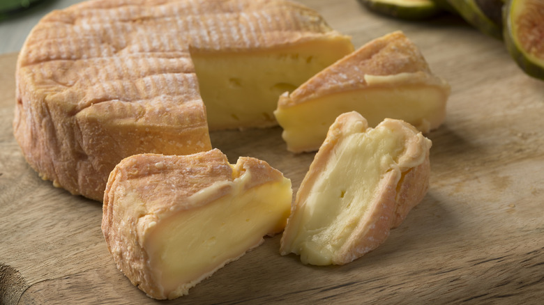 French Munster in wedges on a wooden board