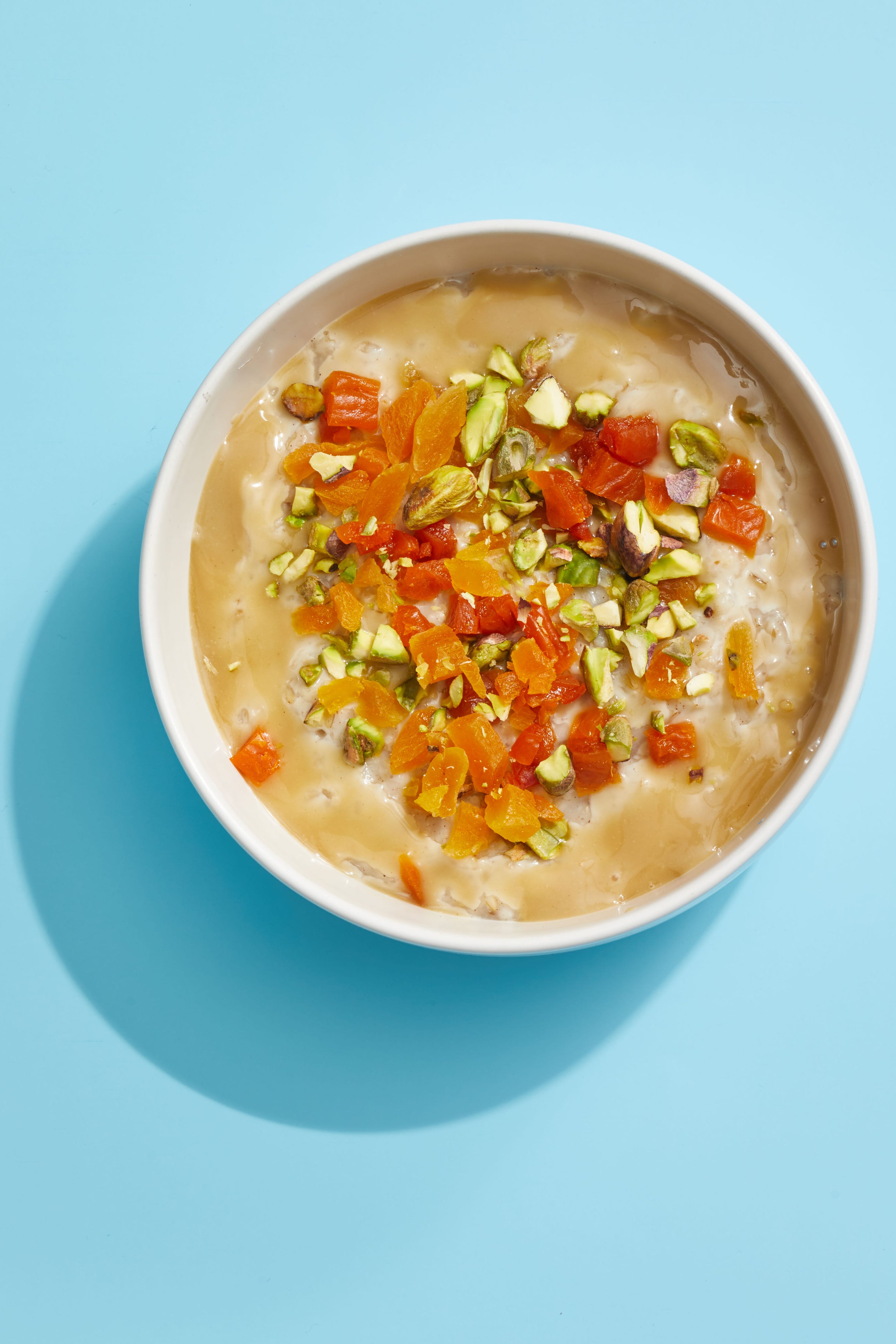 oatmeal with pistachios and apricots on a blue background