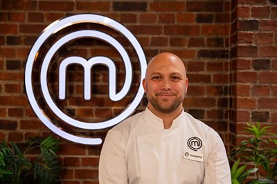 A man in chef whites poses in the MasterChef studio 