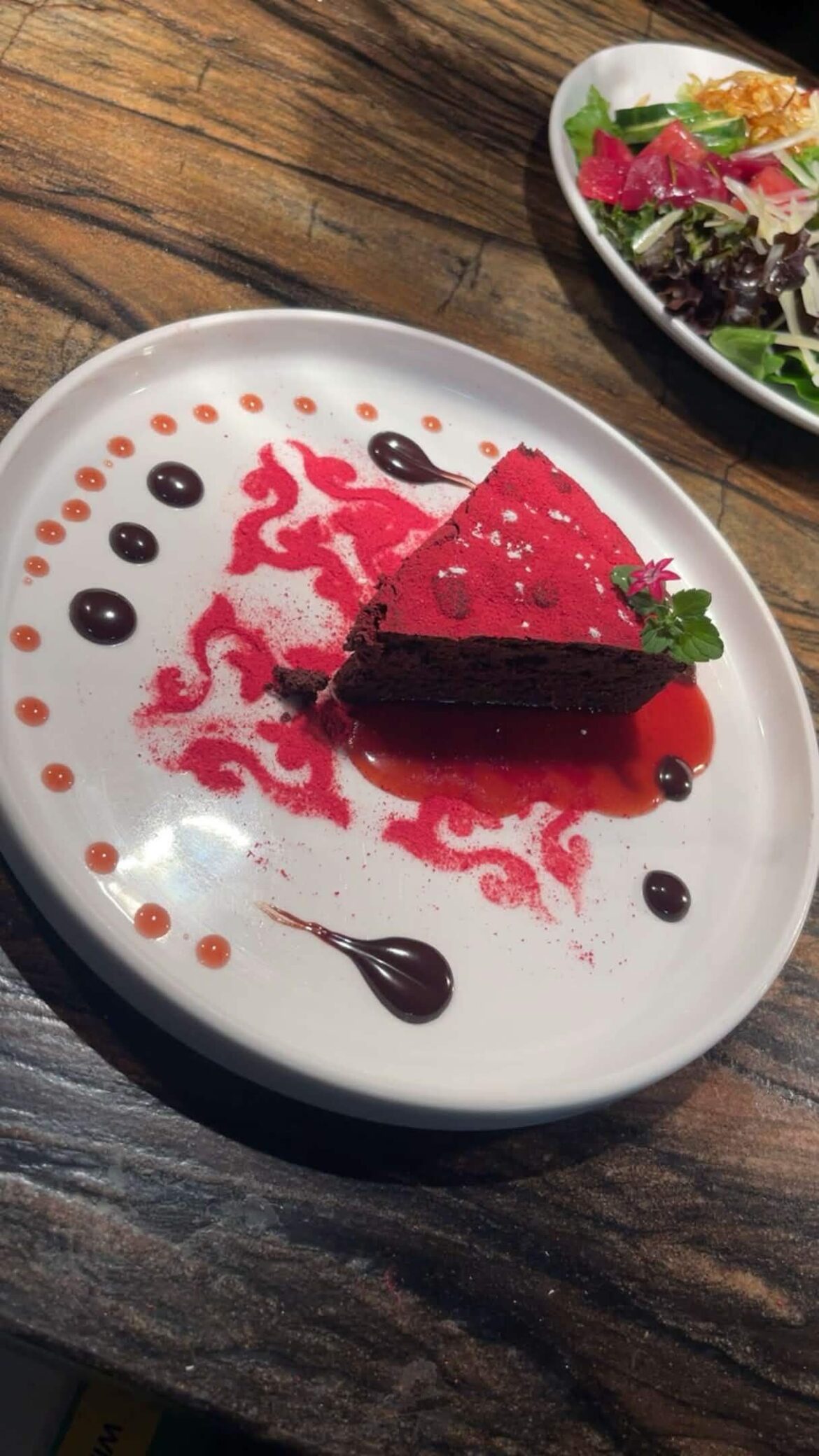 Dark chocolate flourless cake with chocolate strawberry gnace and a strawberry Chianti coulis