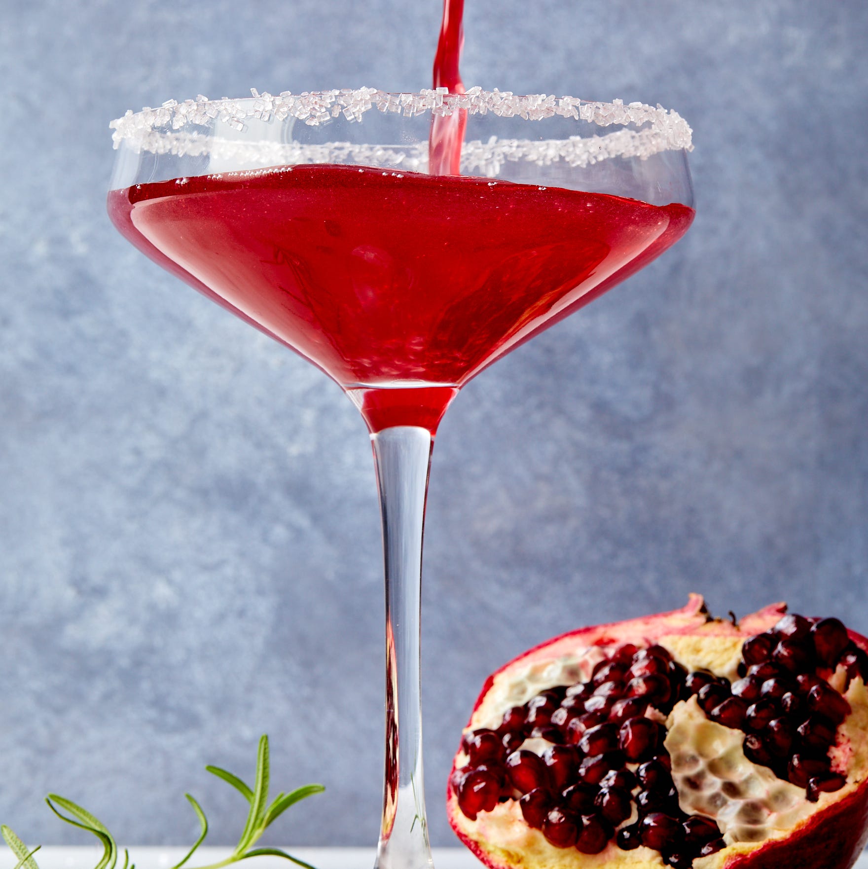 pomegranate martini in a glass with a sanding sugar rim
