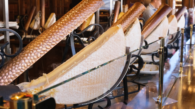 A line of heat lamps with half-wheels of Raclette