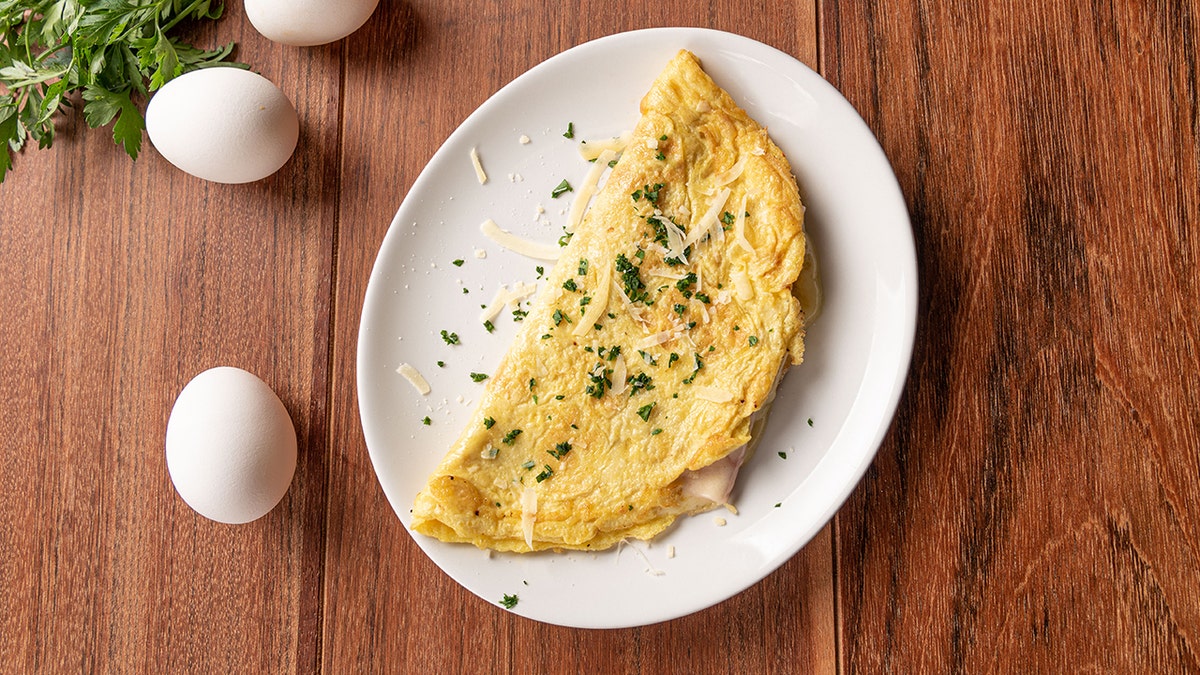 Omelet with parsley, cheese next to eggs