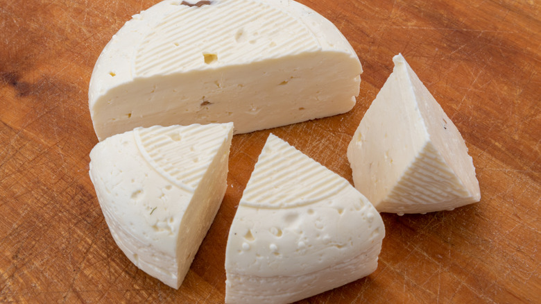 Robiola cheese cut into wedges on a wooden board