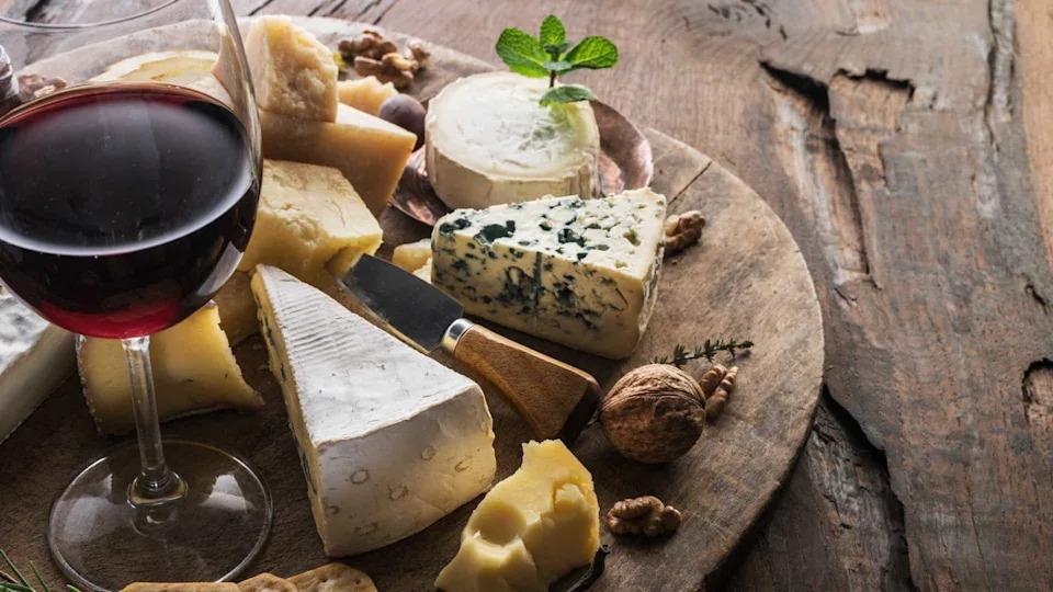 Tray of cheeses with a glass of red wine