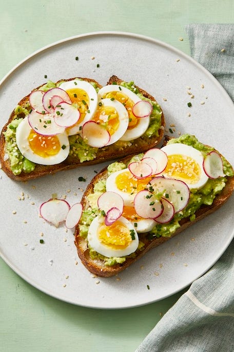 smashed avocado toast with jammy eggs and radish slices on top