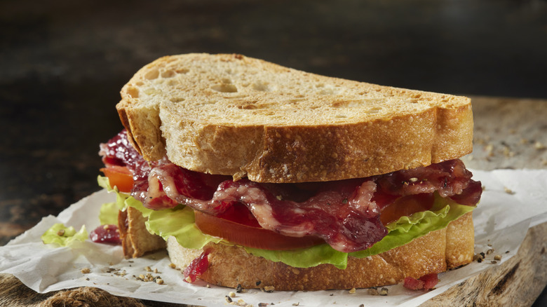 Bacon, lettuce, and tomato sandwich on thick bread on a wooden board