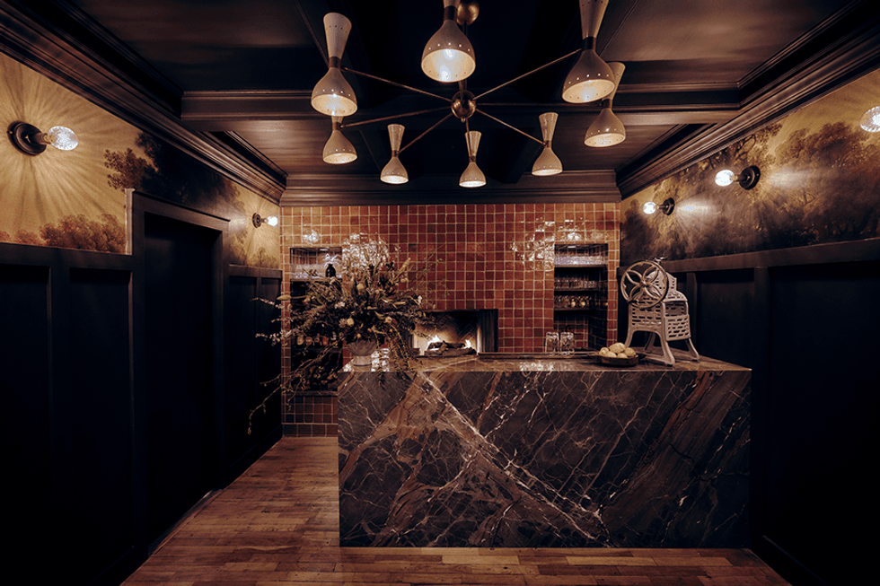 Stylish bar with marble counter, vintage decor, and warm lighting.