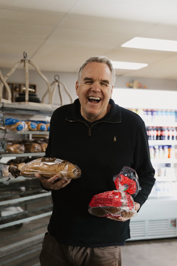 Michael Brewer holds some of the bread products at Dudley's Bakery in Santa Ysabel, which he recently purchased with business partner Michel Malécot. (Kaliana Caldwell)