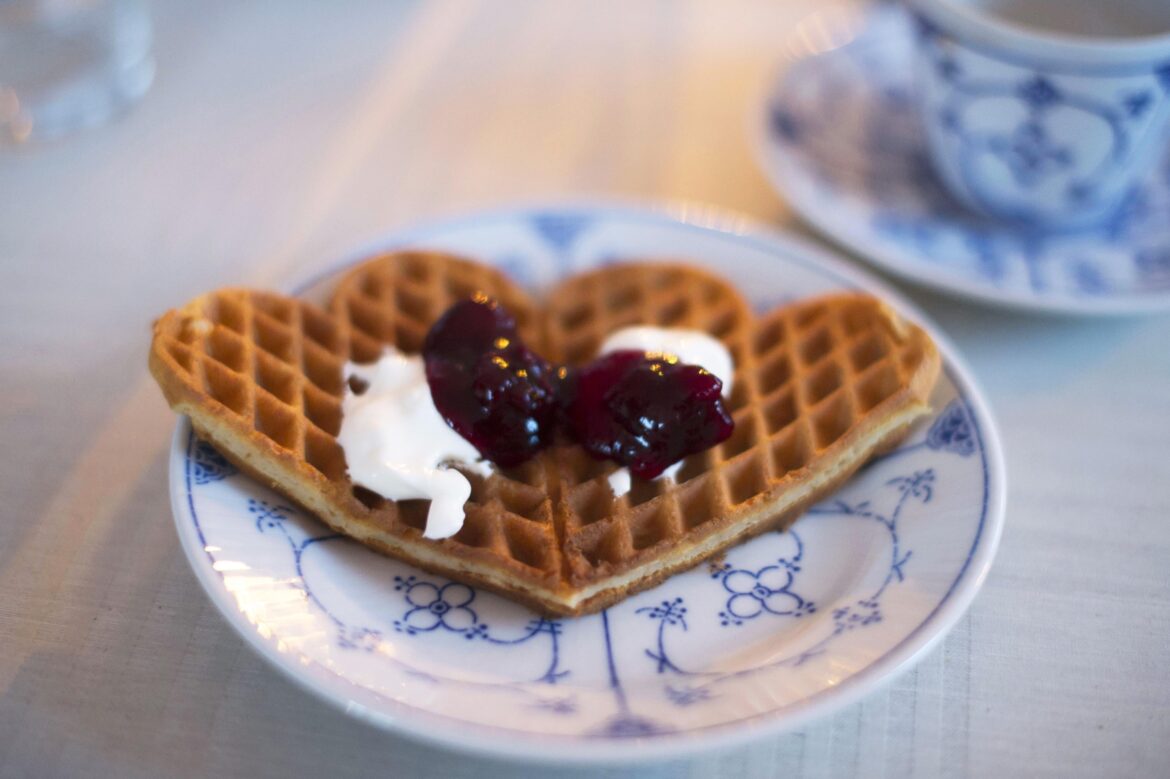 Home made heart-waffles with cherry jam and clotted cream
