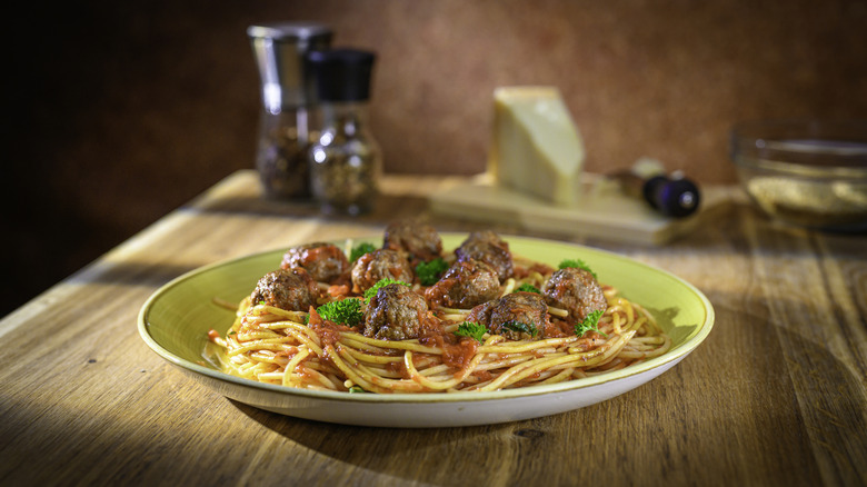 Close-up of meatballs with pasta served in plate on table.