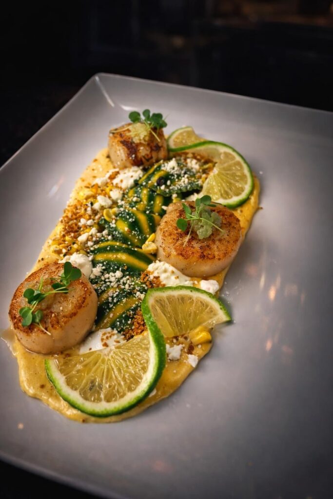 Roasted Corn and Ricotta Ravioli, Scallops, Corn Puree, Cilantro Crema, Lime Pearls, Queso Fresco, Chili Breadcrumb Crunch, Roasted Corn