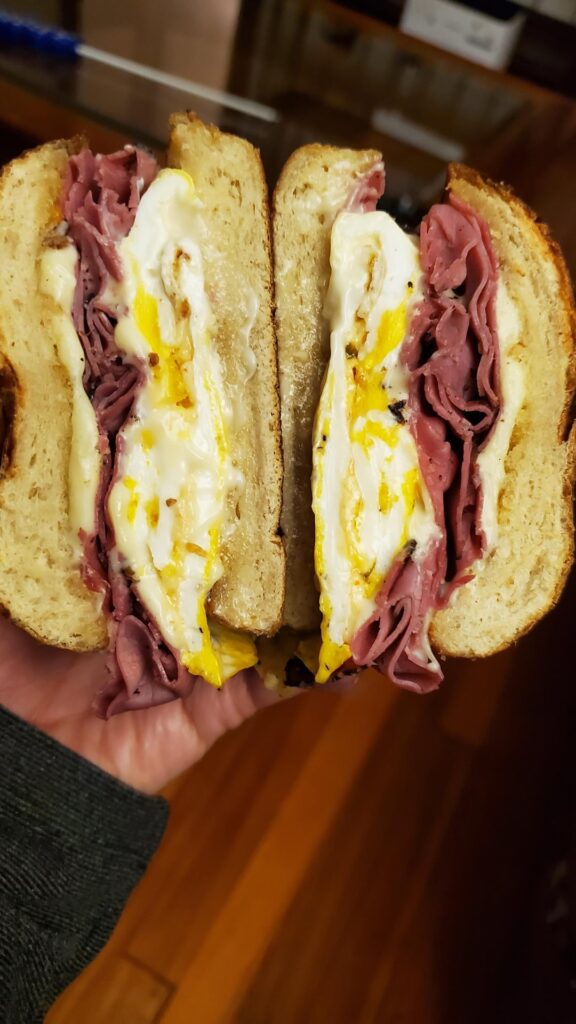 Fried two eggs with pastrami on pretzel bun.