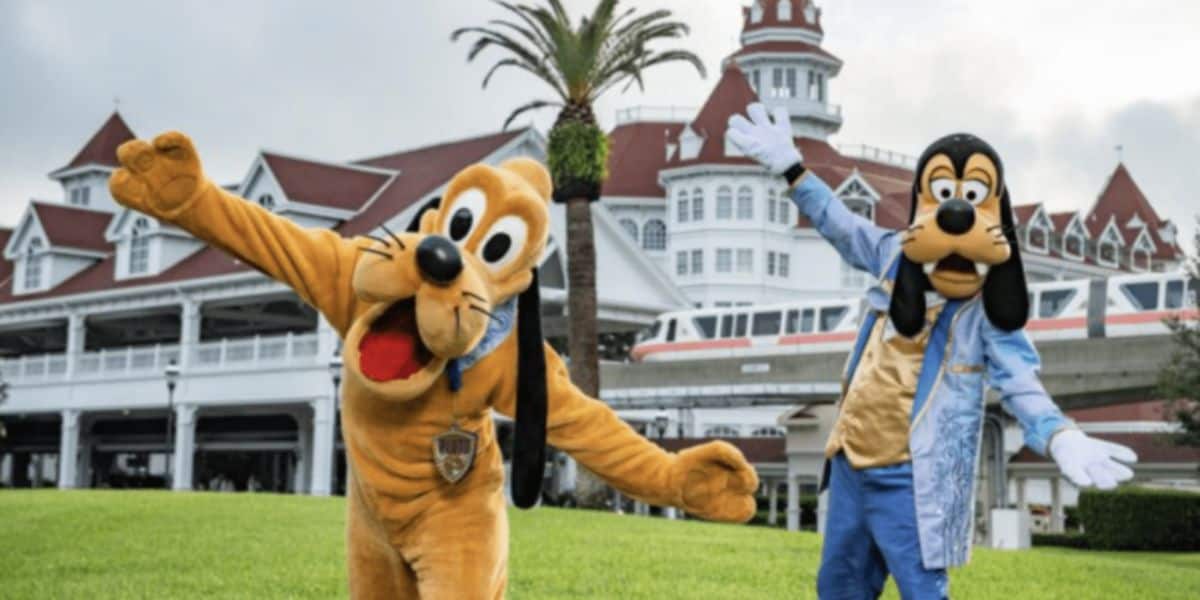 Pluto and Goofy wave in front of the Grand Floridian