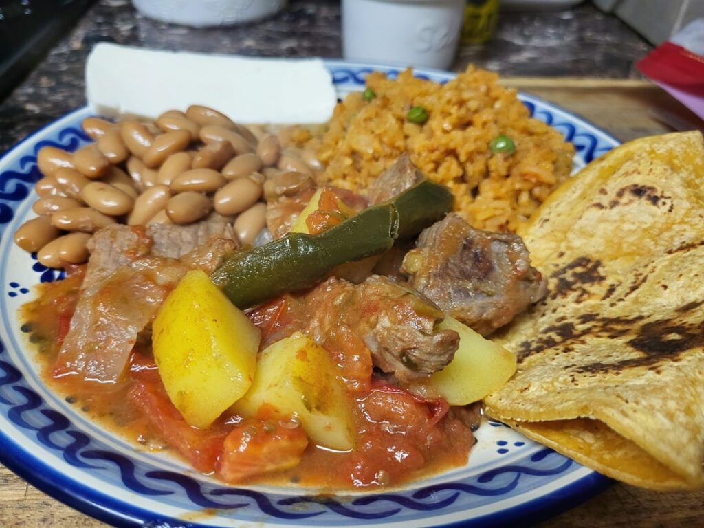 The rain is pouring so I cooked Bistec Ranchero, frijoles de la olla and arroz for her.