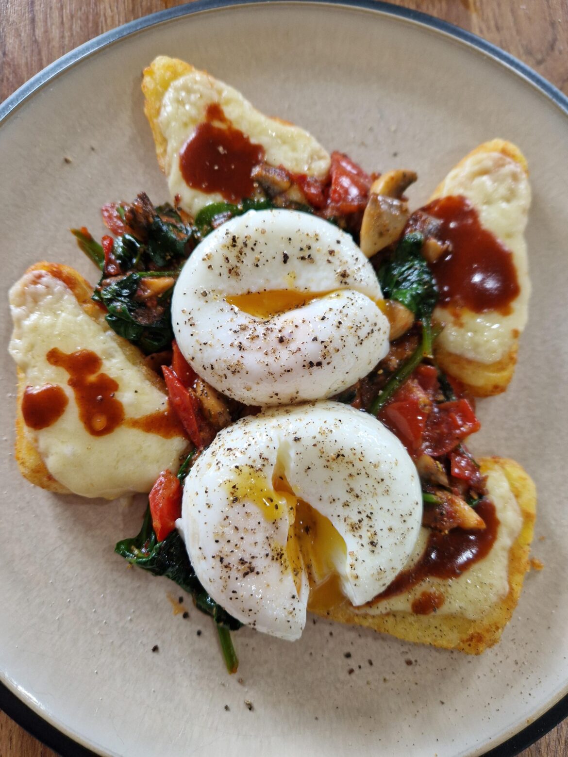 Cheesy hash browns, poached eggs, tomatoes, mushrooms, and spinach