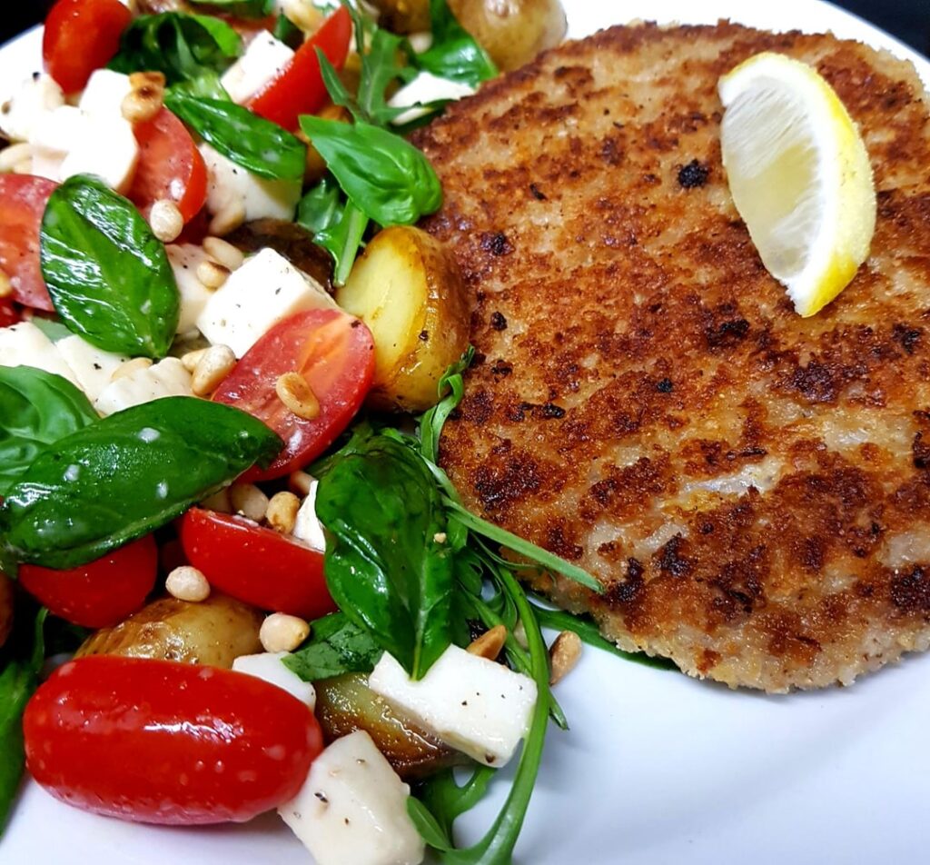 Pork Milanese with Baby Potatoes and a Rocket Caprese Salad. Homemade Parmesan and Lemon Zest Breadcrumbs.