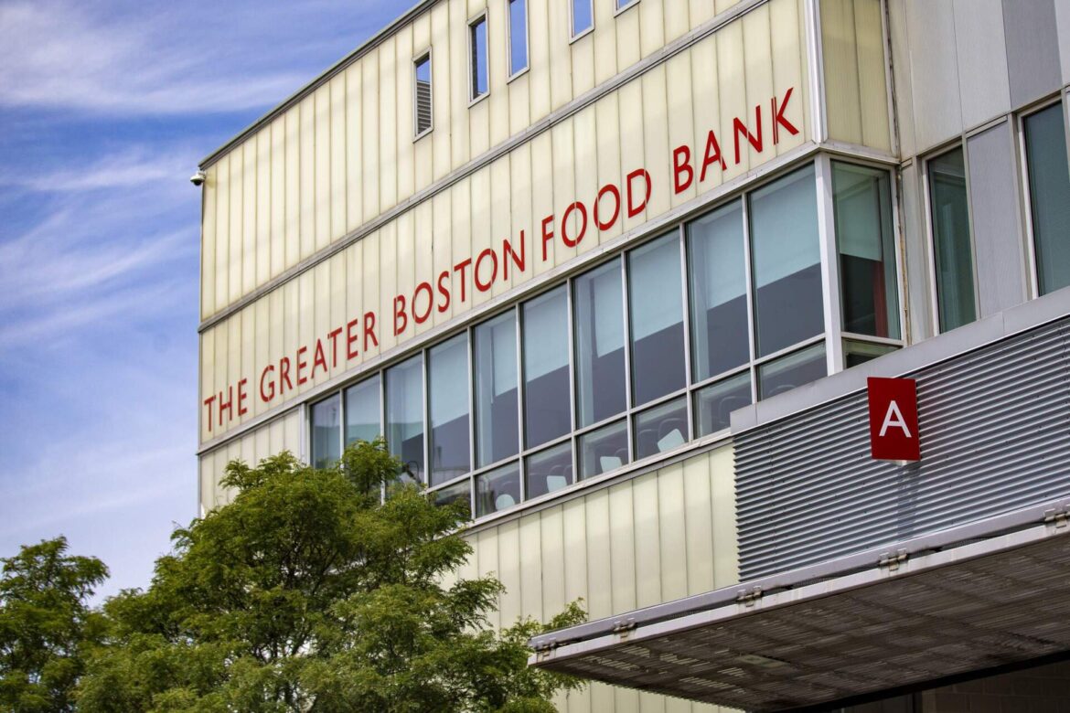 In this 2020 photo, Greater Boston Food Bank warehouse associates move pallets of food to the loading dock to be distributed around the Greater Boston area. (Jesse Costa/WBUR)