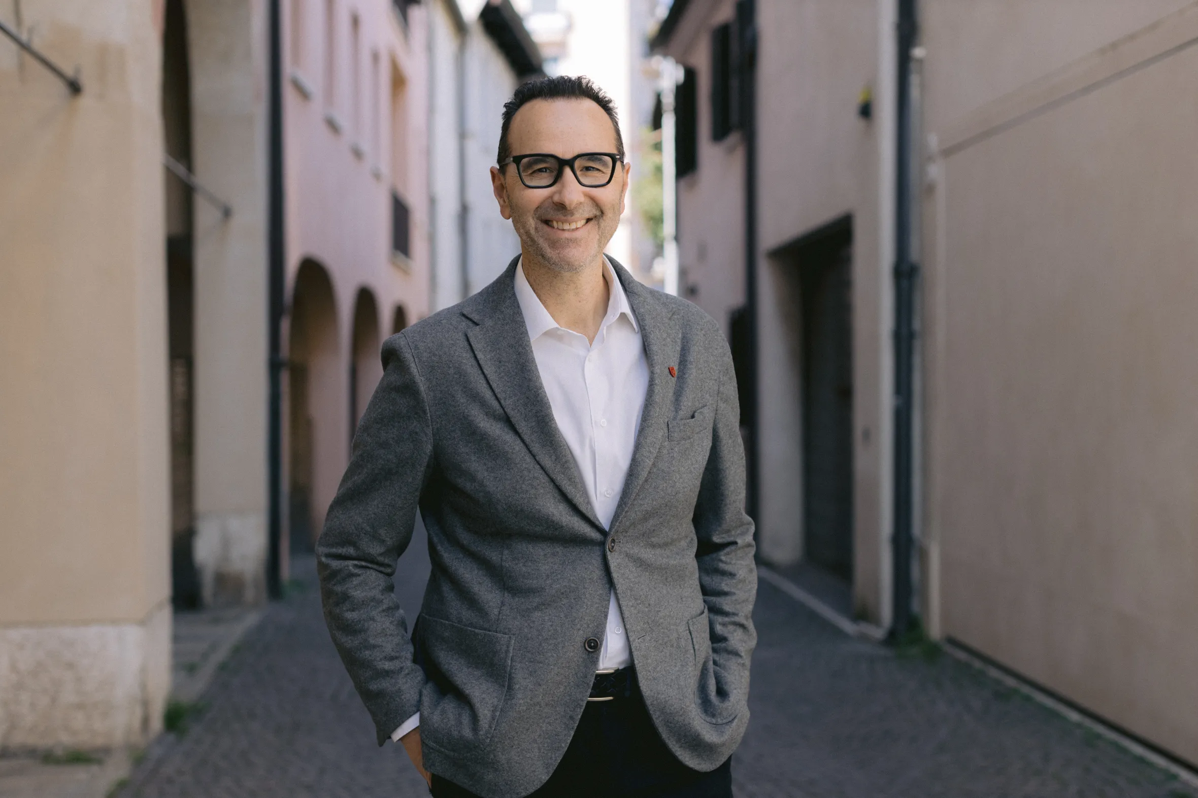 Francesco Redi, creator of Tiramisù World Cup and Tiramisù Academy, smiling while standing on a cobbled street.
