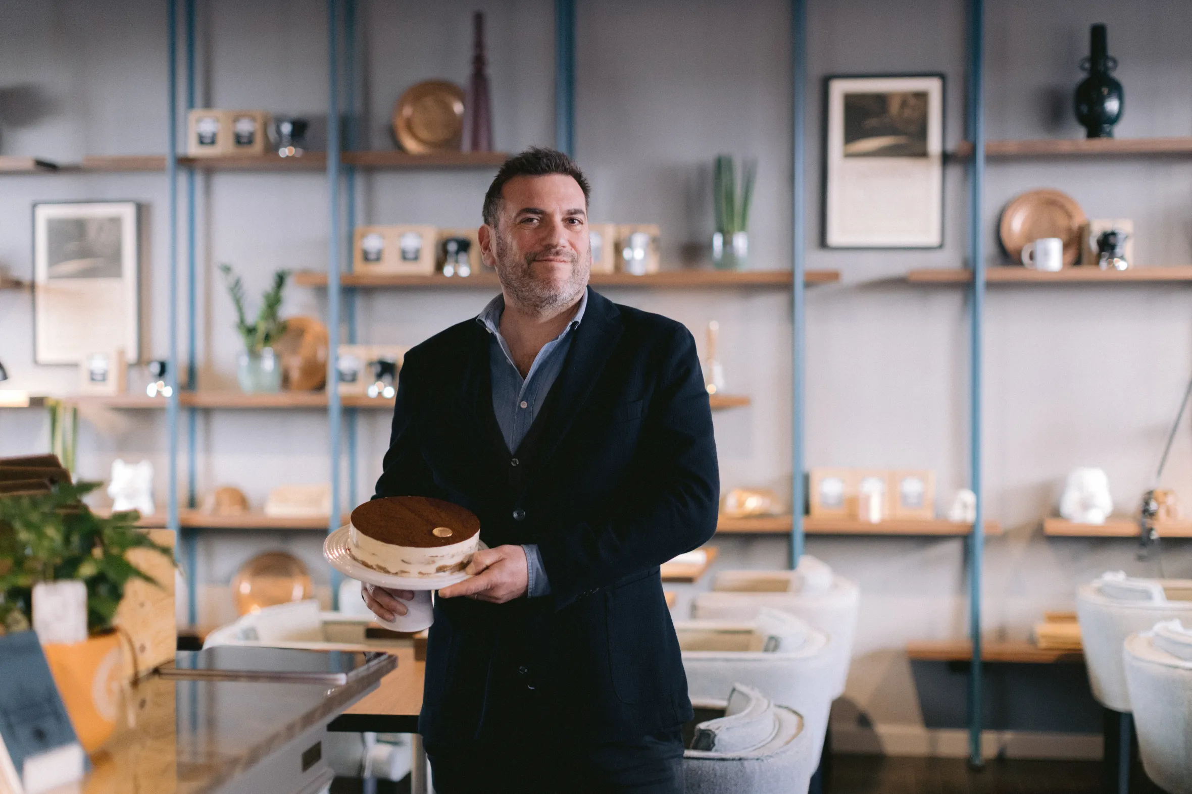 Paolo Lai holding a tiramisu cake.