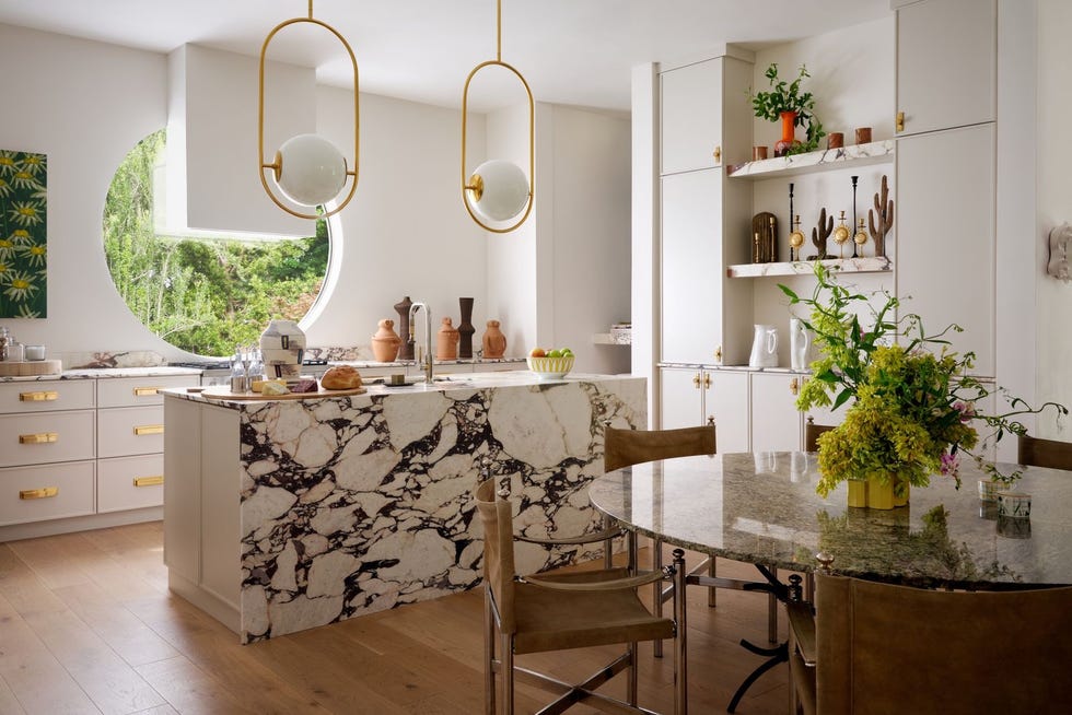 Modern kitchen with circular window and luxurious finishes.