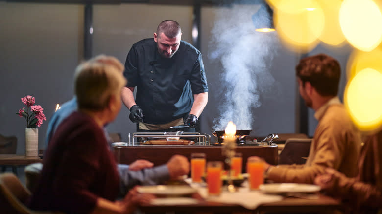 A chef flambeeing food.