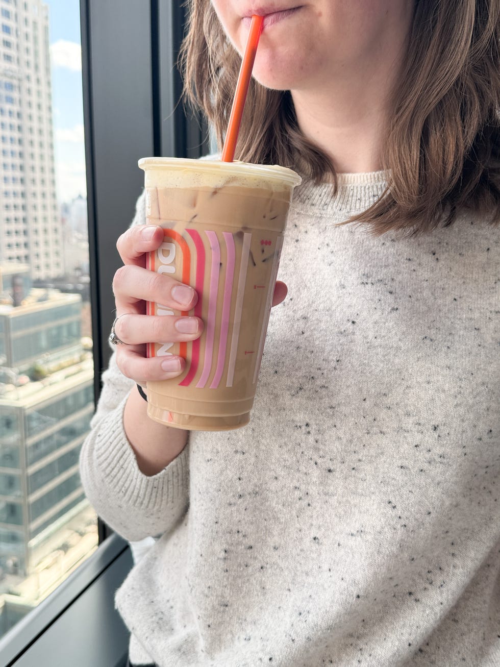 Person holding an iced coffee drink with a straw. Person holding an iced coffee drink with a straw.