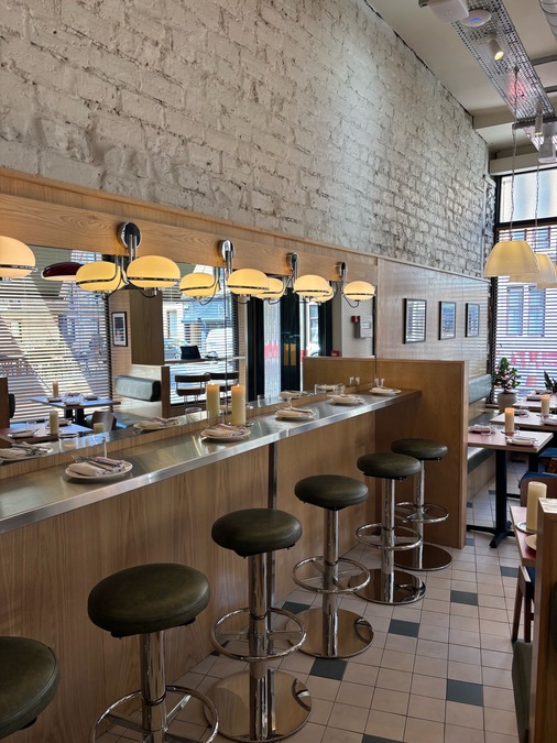 A photo of the interior at Corner Shop, Glasgow. A bright cafe bar with a raised counter and high stools.