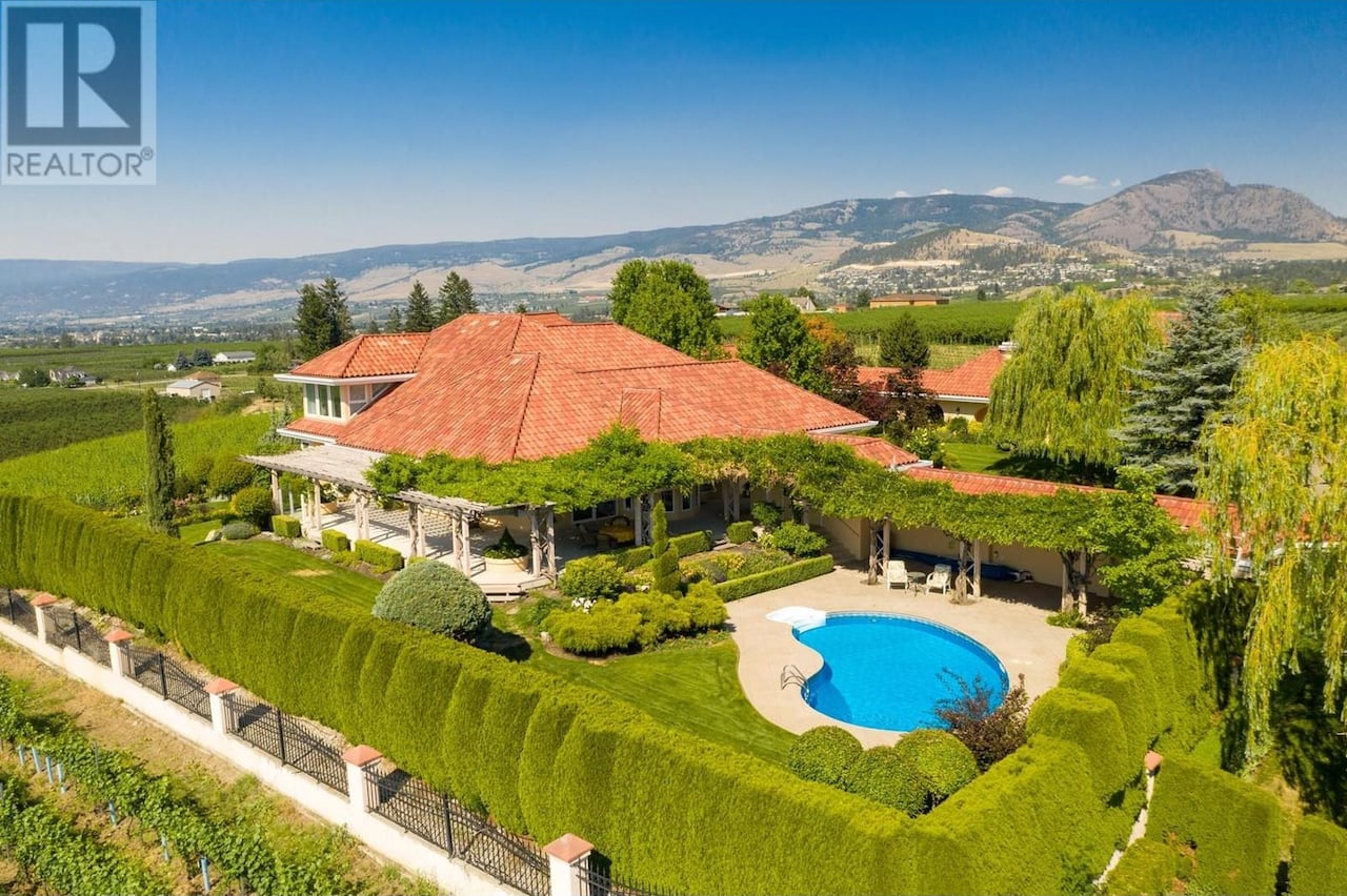 A large villa property with a pool in the foreground.