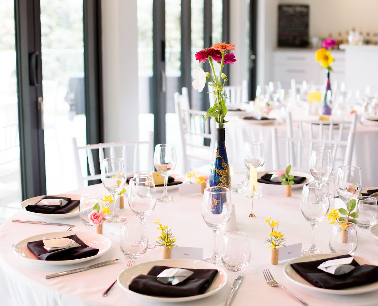 A table set up with wine glasses and an elaborate wine bottle in the centre.