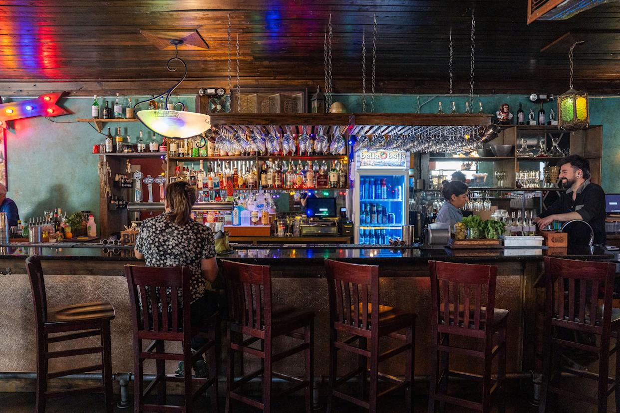 Customers sit at the bar at Bella Bella, Wednesday, April 15, 2026.