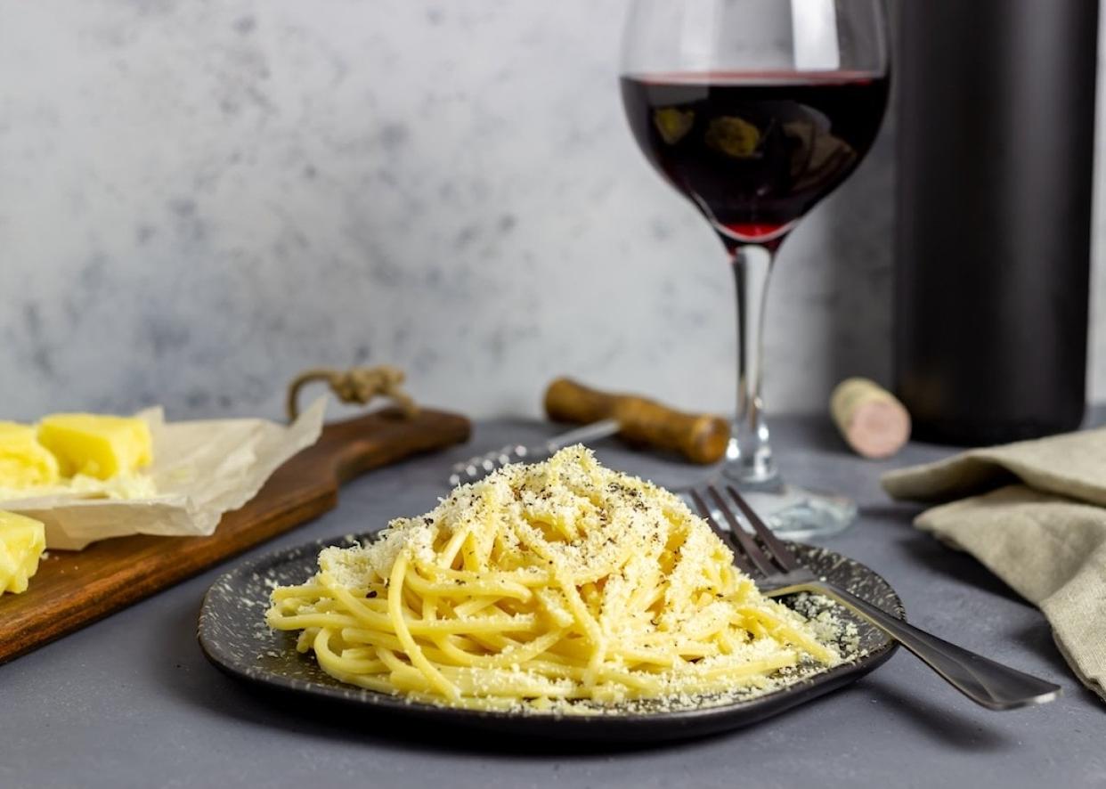 Roman pasta spaghetti cacio e pepe with black pepper, cheese, and wine. - 