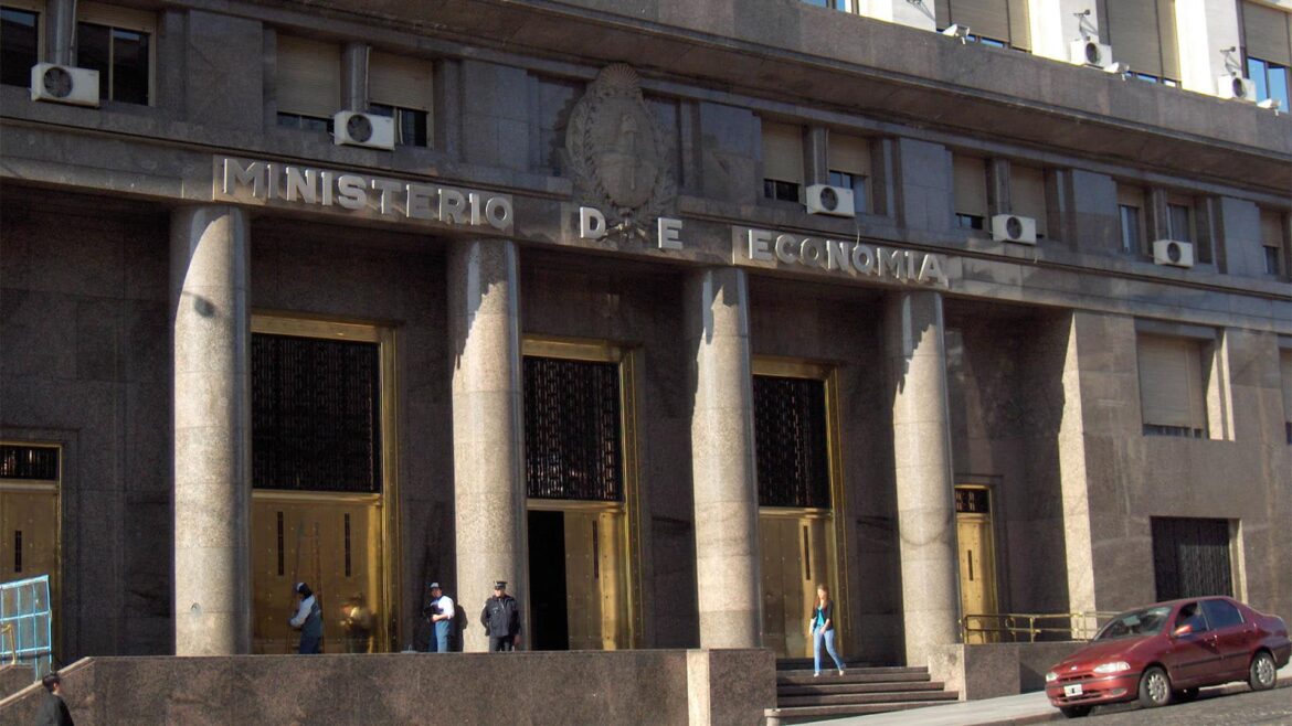 Facade of the Ministry of Economy headquarters in Buenos Aires, Argentina. Three people queue while a policeman watches them. A man (in a suit with a briefcase) and a woman (walking in the opposite direction) pass by on the pavement.