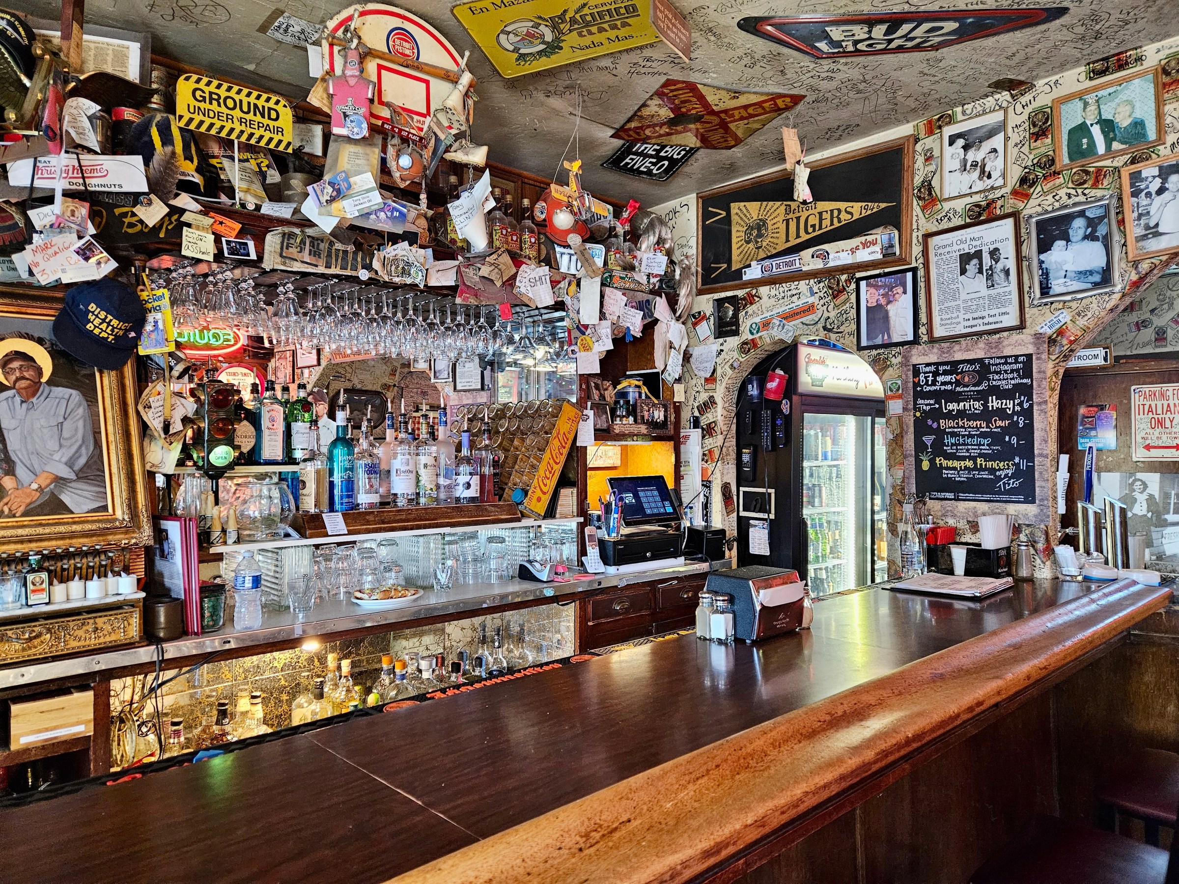 Interior of Casale’s Halfway Club with a wood bar and bottles behind the bar.