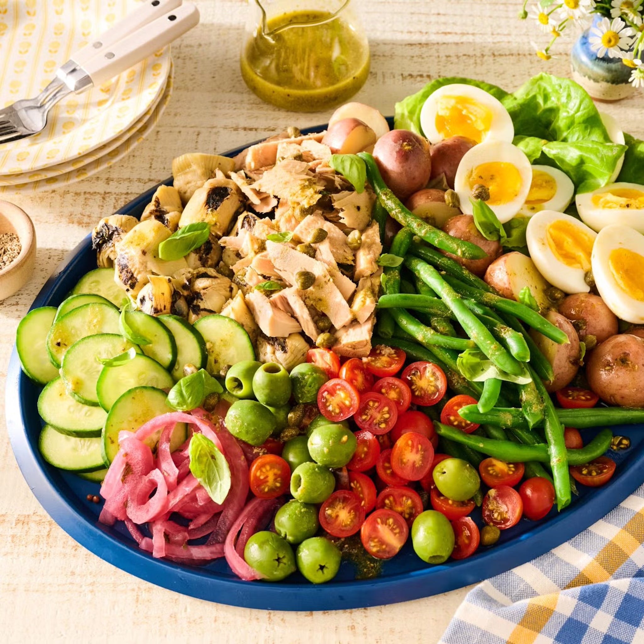 Platter of colorful salad with various vegetables and proteins.