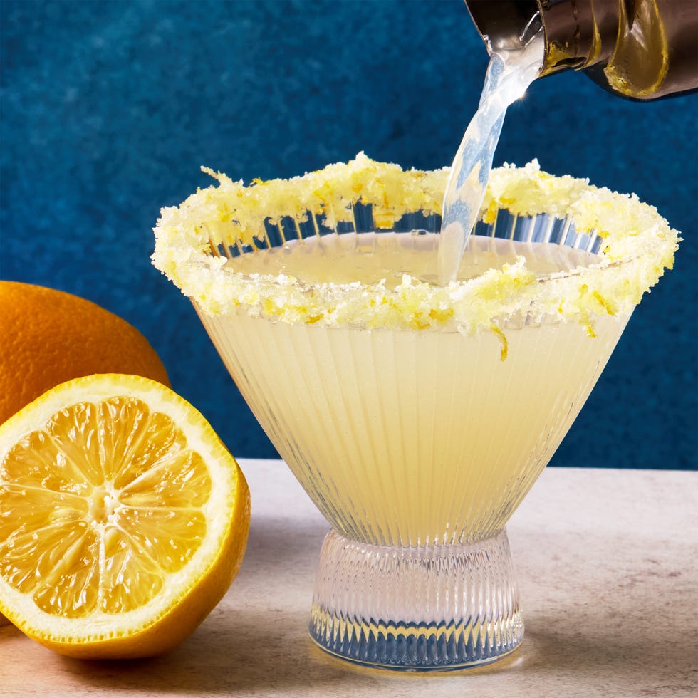 Lemon drop martini in clear, stemless martini glass with a sugar and lemon zest rim and lemon twist