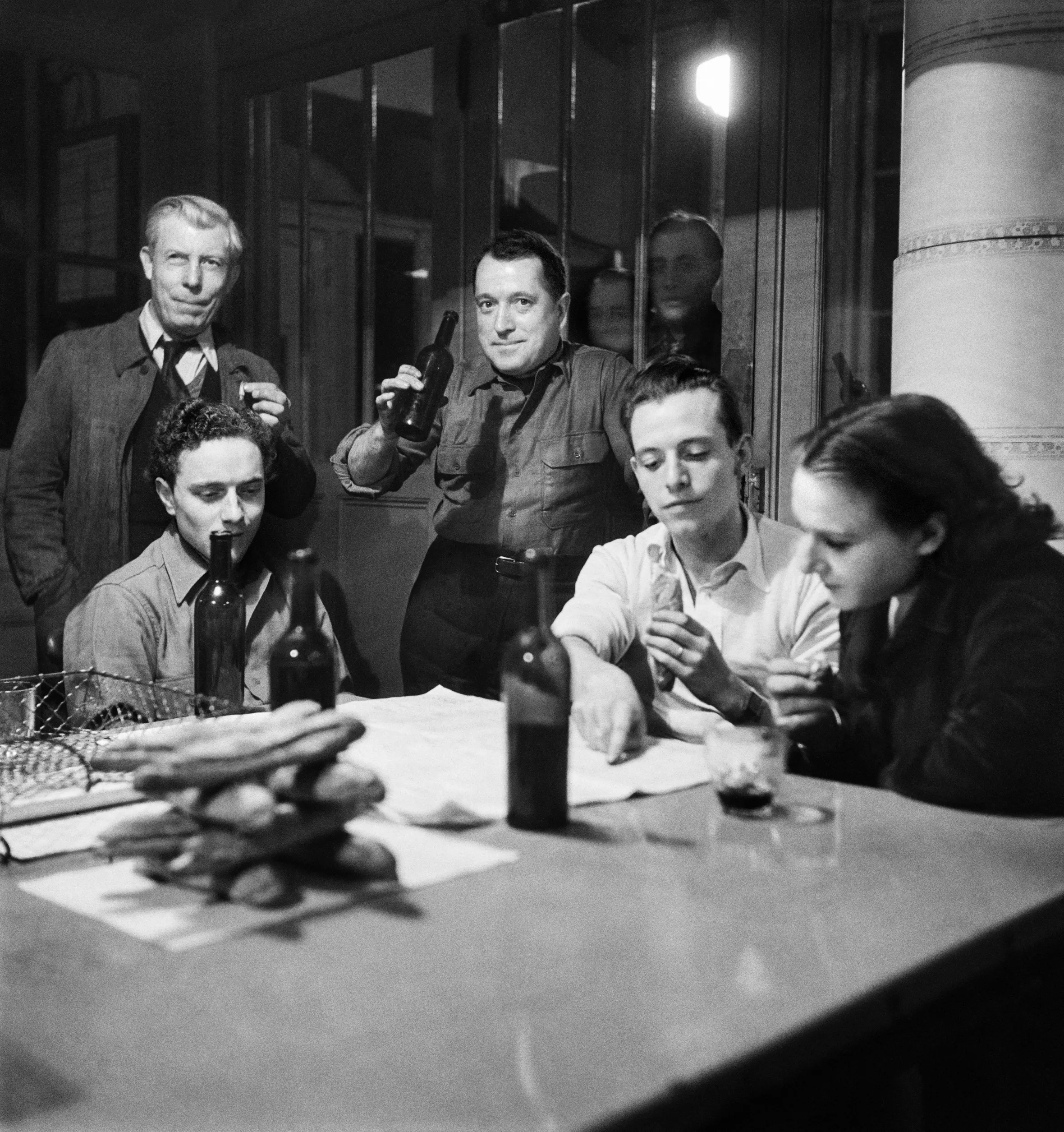 Journalists from AFP taking a lunch break around a table with bread and drinks.
