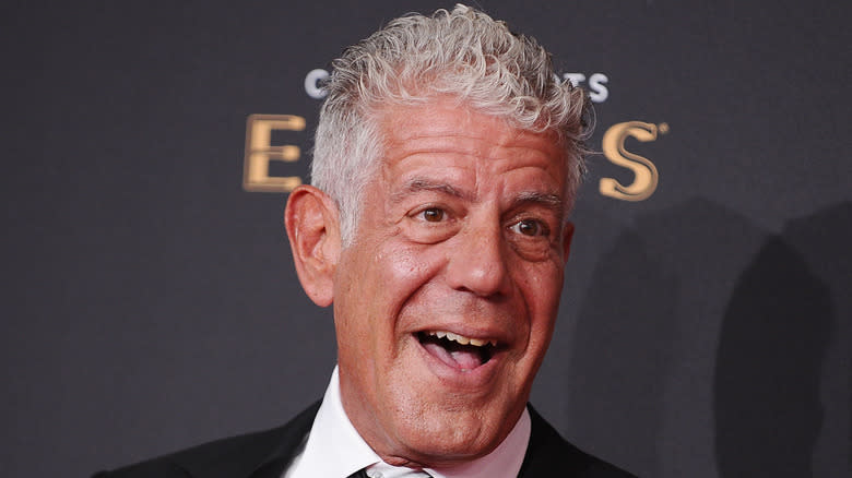 Anthony Bourdain open-mouthed smiling at an event.