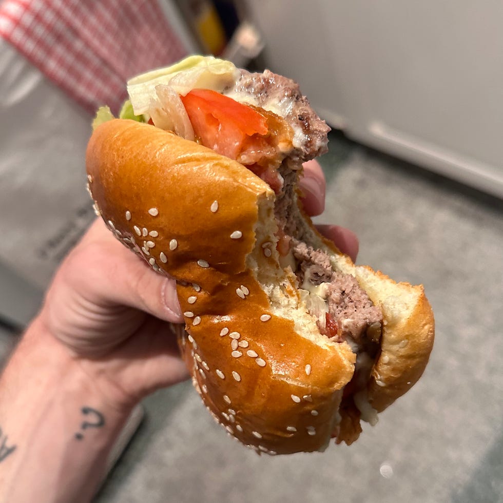 Half-eaten hamburger held in a hand.