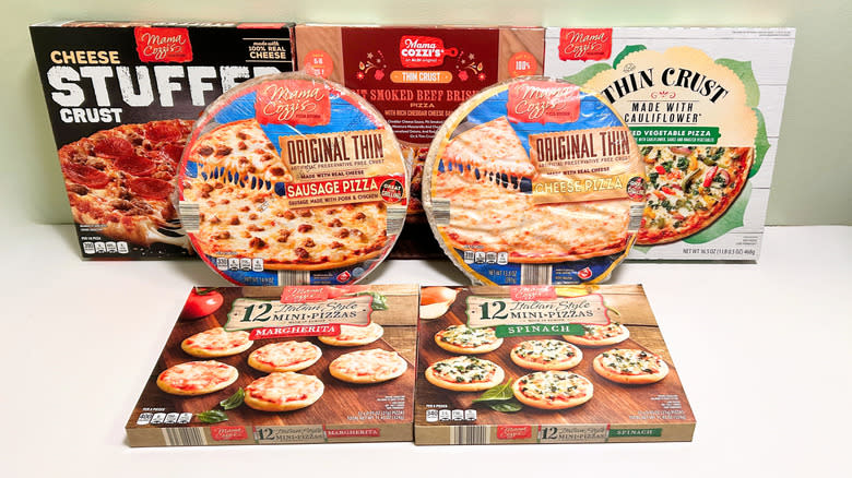 Seven Mama Cozzi's pizzas from Aldi arranged together on a green and white background