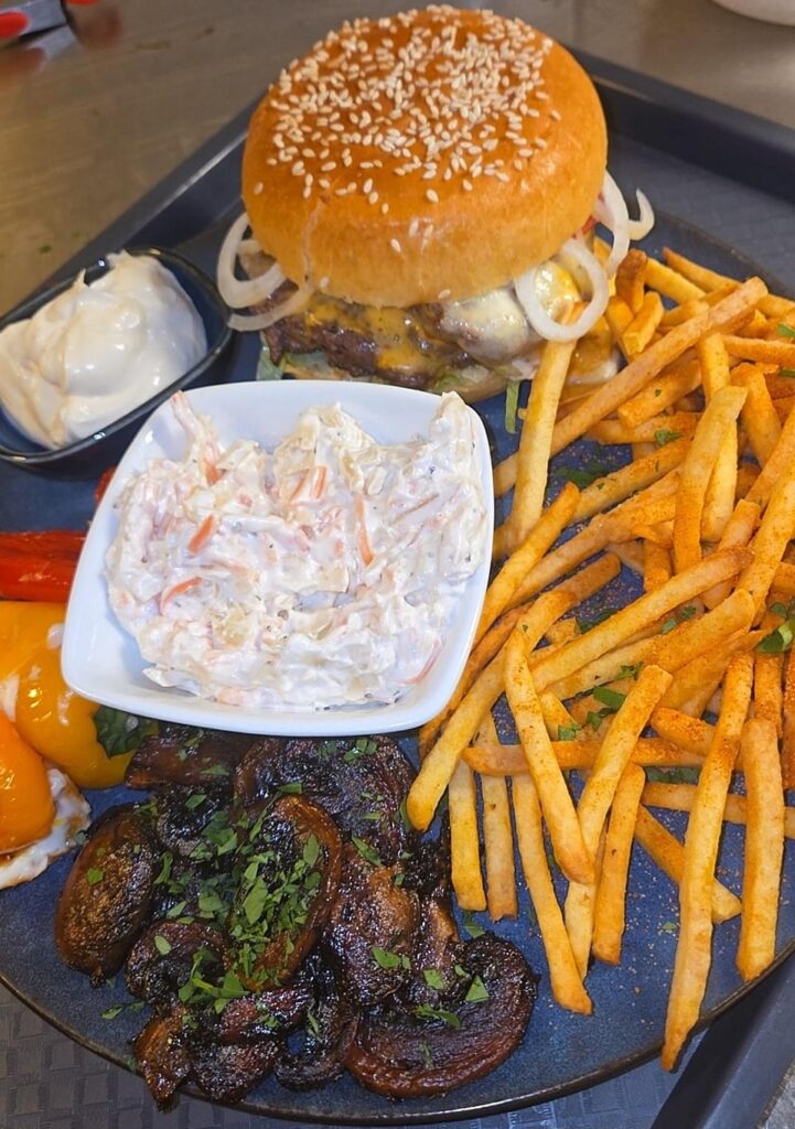 Burger with fries, truffle mayo, balsamic-sautéed mushrooms with garlic, cream cheese-stuffed peppers, and coleslaw