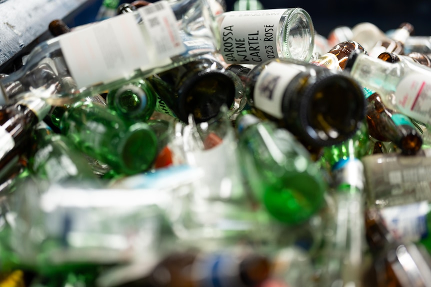 A pile of glass bottles in a bin.