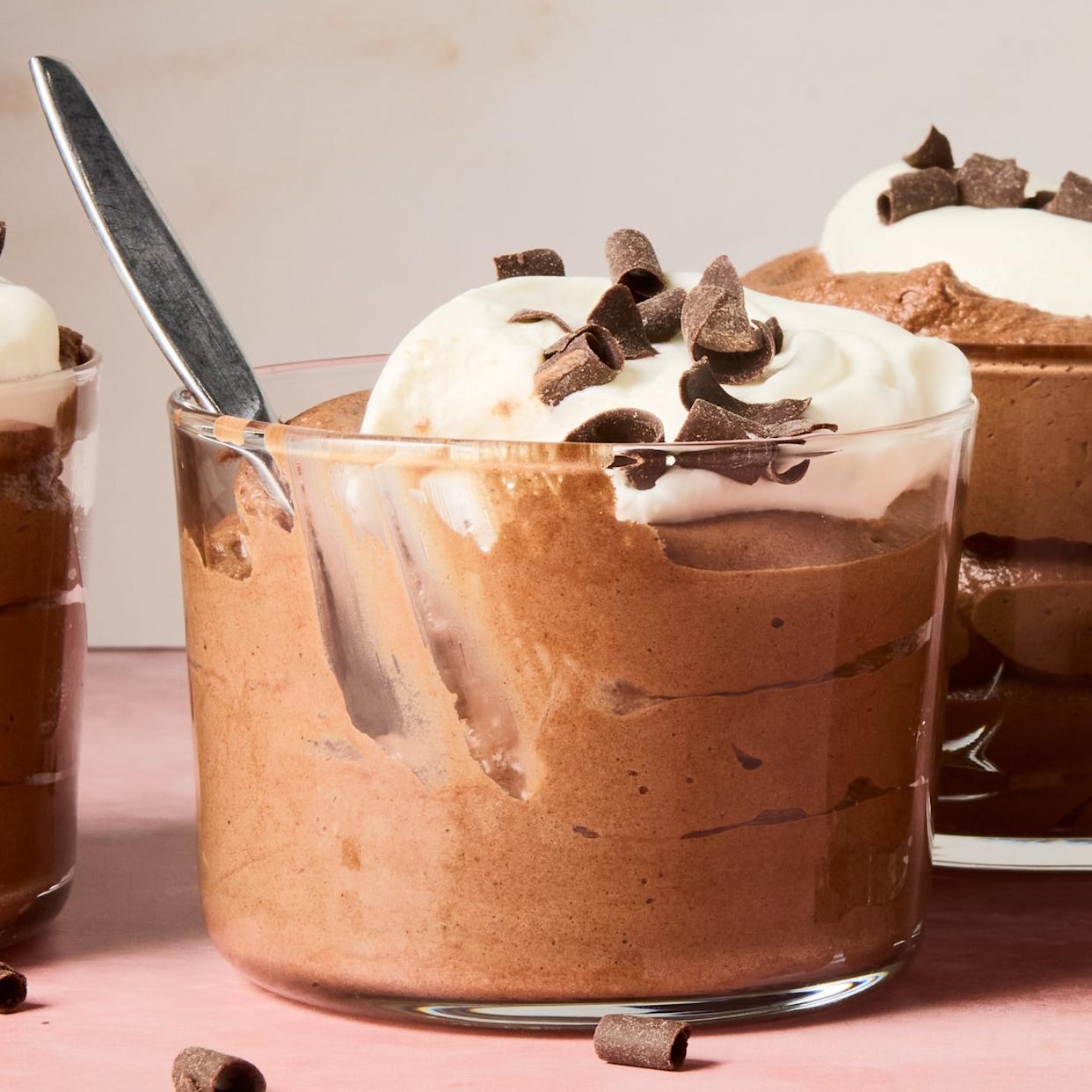 chocolate mousse in containers topped with whipped cream and chocolate shavings