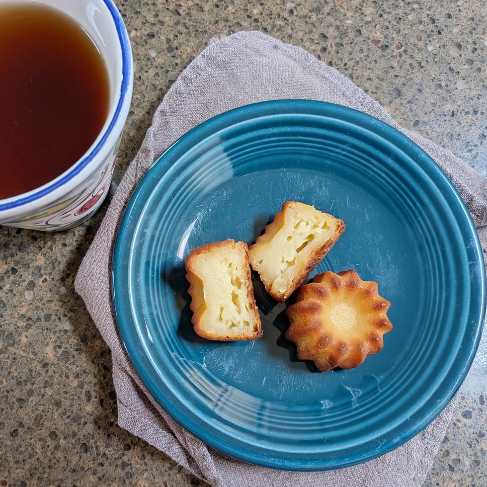 A cup of tea alongside a plate of cut pastries.