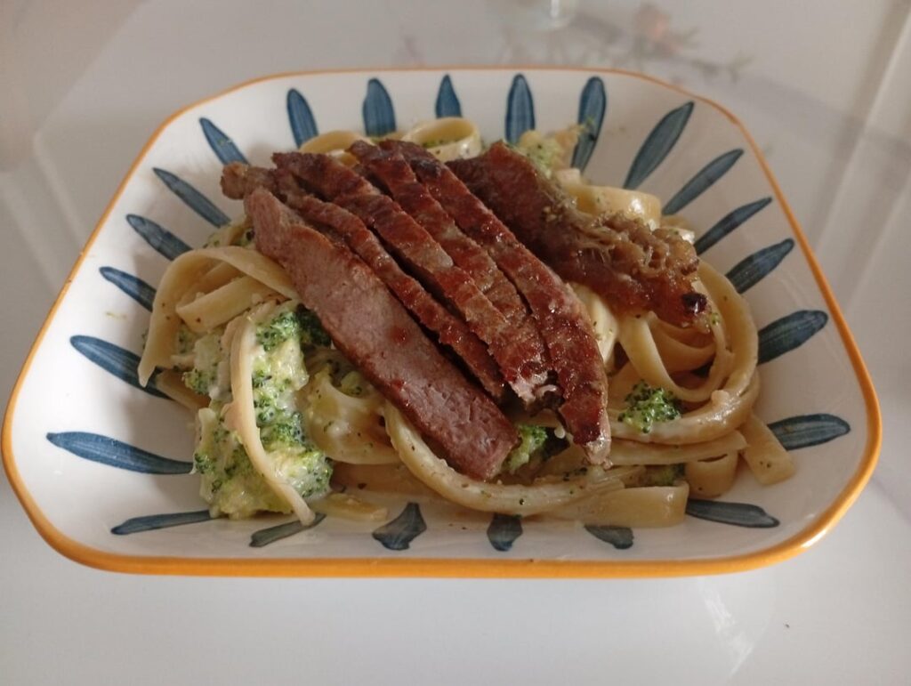 Broccoli Alfredo Fettuccine with a steak on top