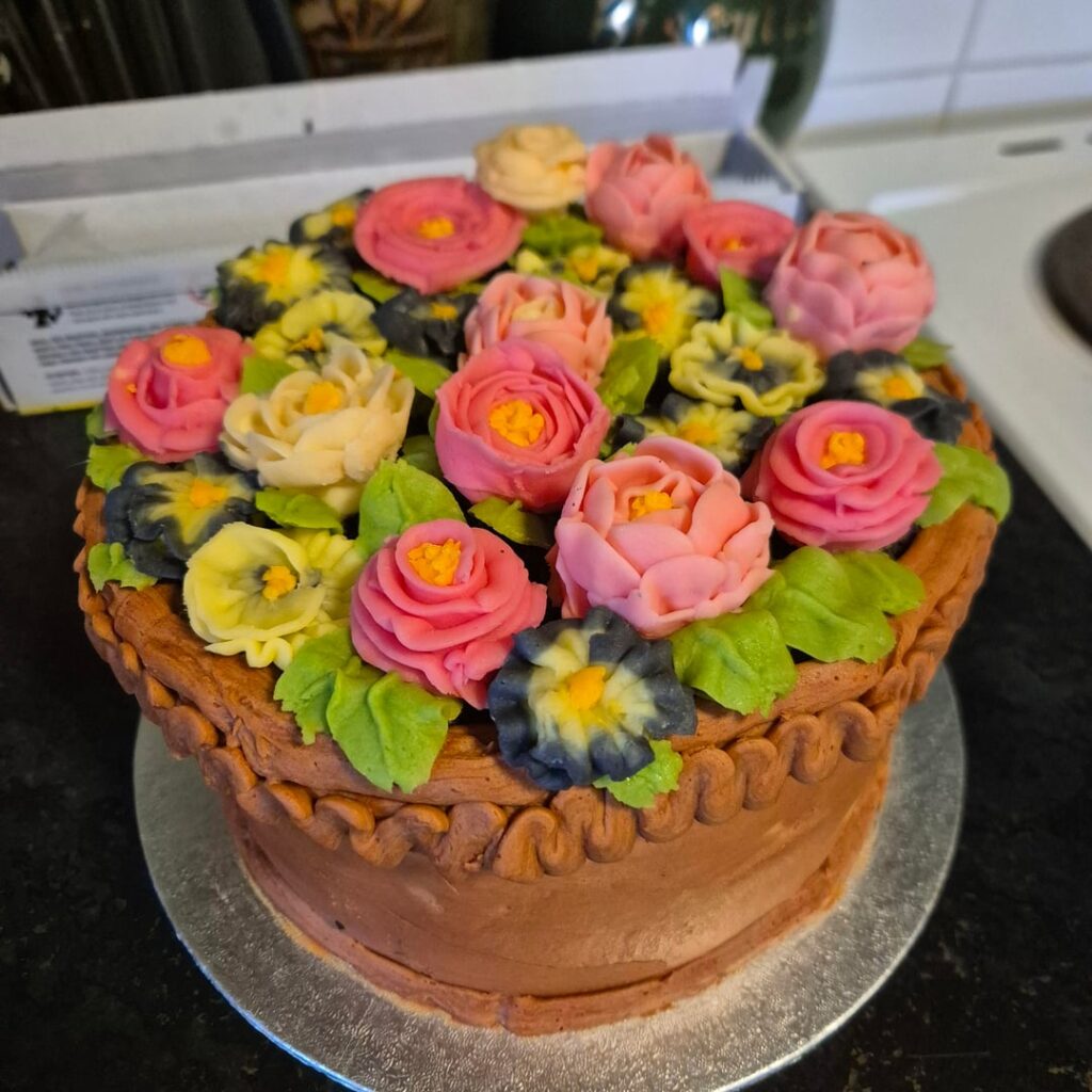 This might be the best cake ive made so far, chocolate sponges, vanilla buttercream on the bottom layer and blackberry jam on the top layer, with a mix of chocolate and vanilla buttercream for the outside and vanilla for the flowers! And blended oreos for the 'soil' under the flowers
