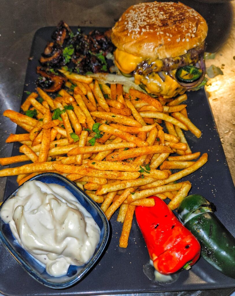 Hamburger once again with French fries, truffle mayo, balsamic-sautéed mushrooms, cream cheese-stuffed snack peppers & jalapeños, and pickled cucumber.
